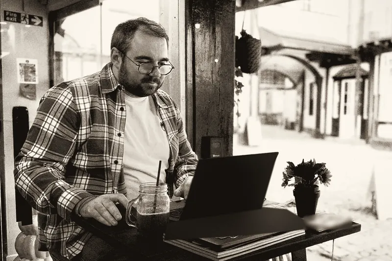 Ryan Russell, founder of Monmouth IT, working on a laptop in a café